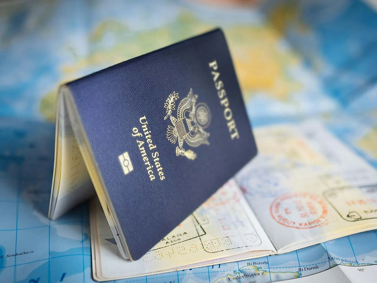 A blue passport and visa documentation on a world map, representing international relocation planning.