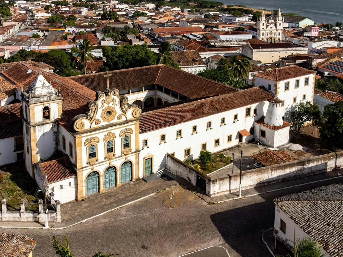 Aerial view of a historic Brazilian colonial town featuring traditional white architecture and clay tile roofs.