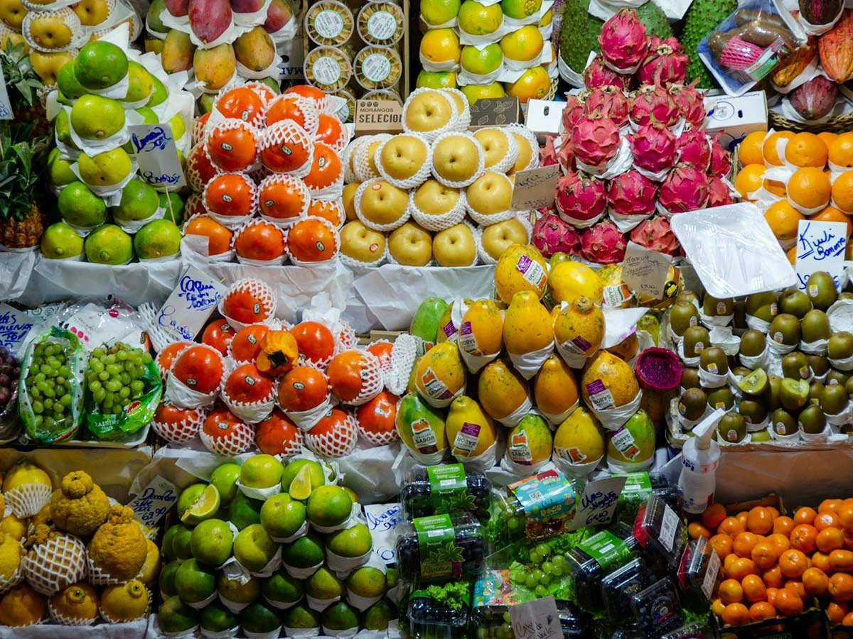 A vibrant display of fresh tropical fruits and vegetables at a local Brazilian outdoor market, highlighting the low cost of living.