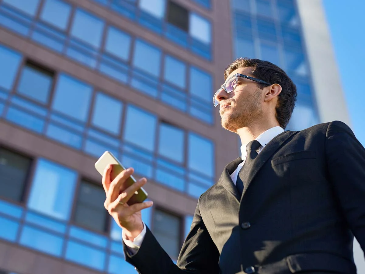 A businessman in a suit standing in front of a modern glass office building, representing foreign investment and property development financing in Brazil.