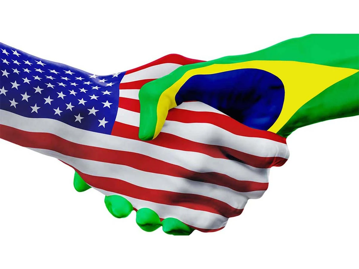 A handshake between hands painted with the US and Brazil flags, symbolizing the financial connection and lifestyle opportunities for Americans living on a US budget in Brazil.
