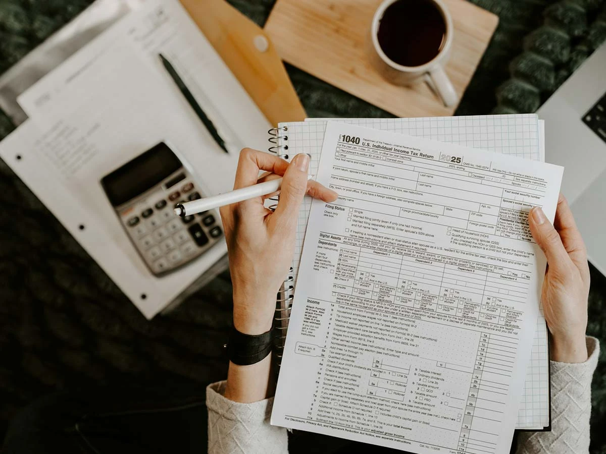 An accountant's desk with IRS tax forms, a calculator, and a pen, representing the annual tax filing process for American expats.