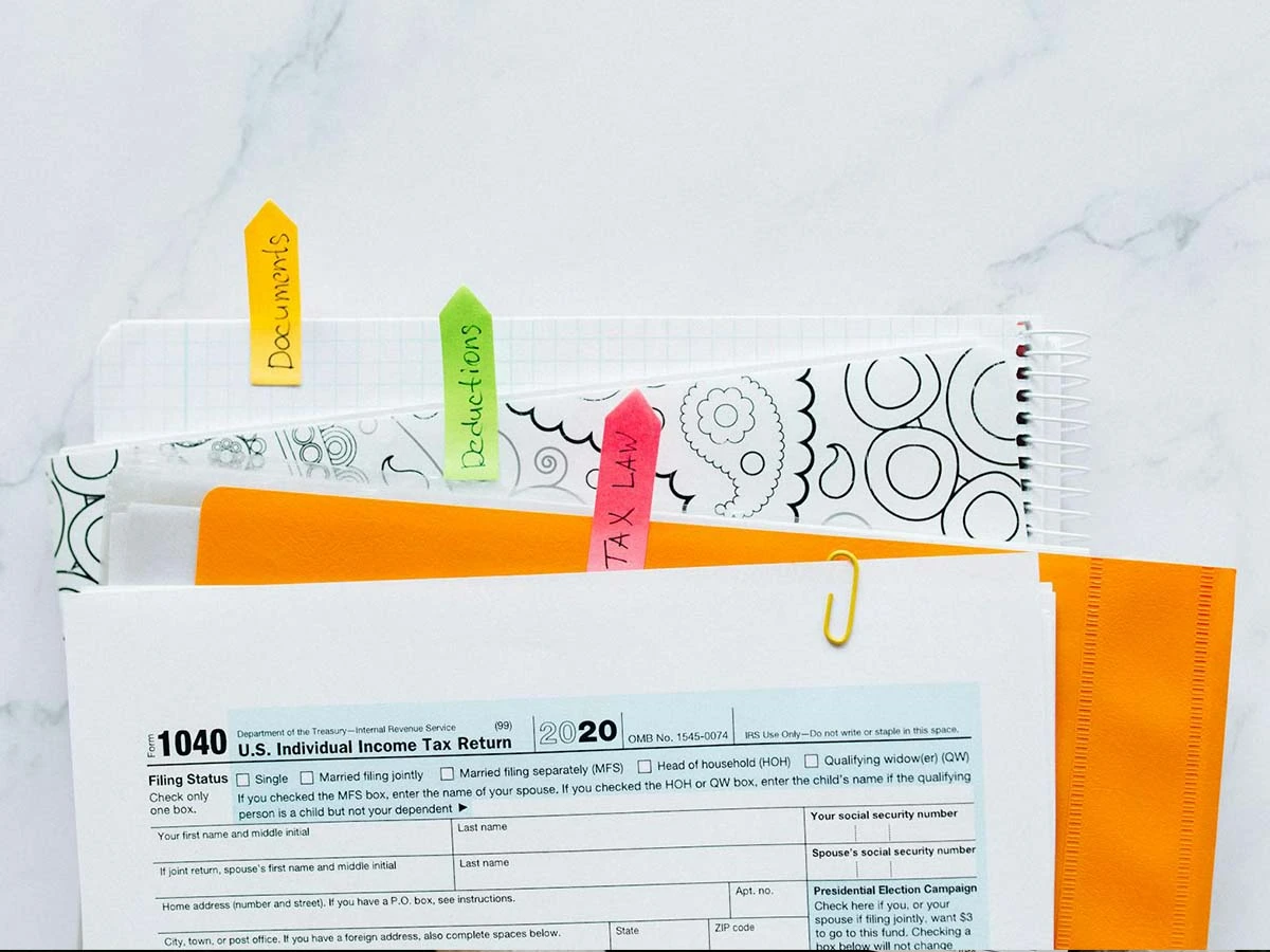 Organized tax compliance folders with color-coded clips, illustrating the documentation needed for filing taxes while living abroad.