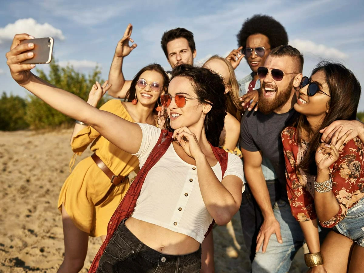 A diverse group of friends taking a selfie at a tropical outdoor gathering, representing the vibrant expat social life in Brazil.