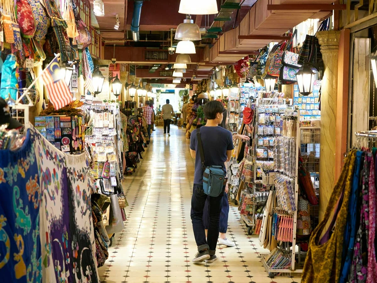 A narrow shopping street in a traditional Brazilian market with colorful textiles and local goods.