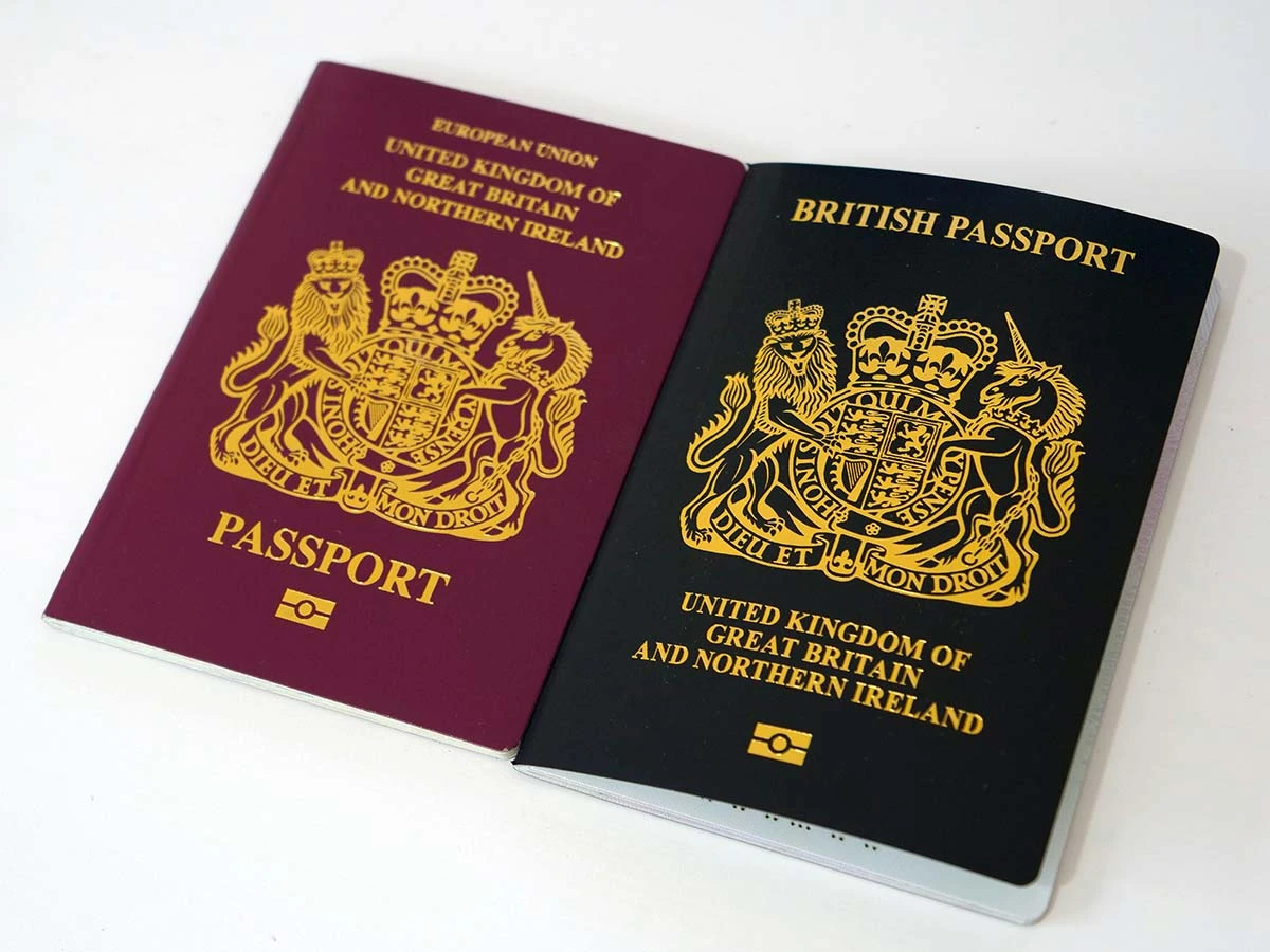 Two British passports (burgundy and blue versions) on a white surface, representing travel and residency options for UK citizens.